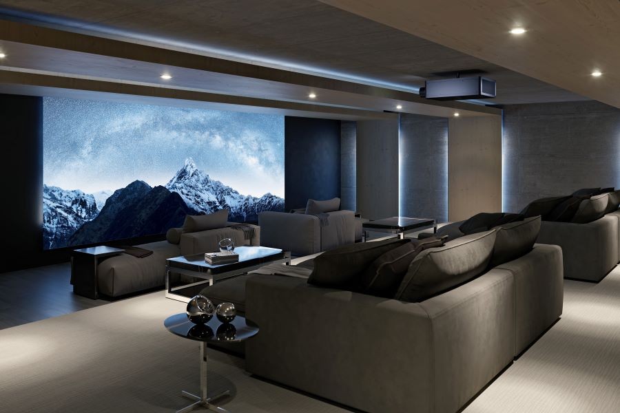 A home movie theater with a Sony projector and a large movie screen depicting snow-covered mountains. 