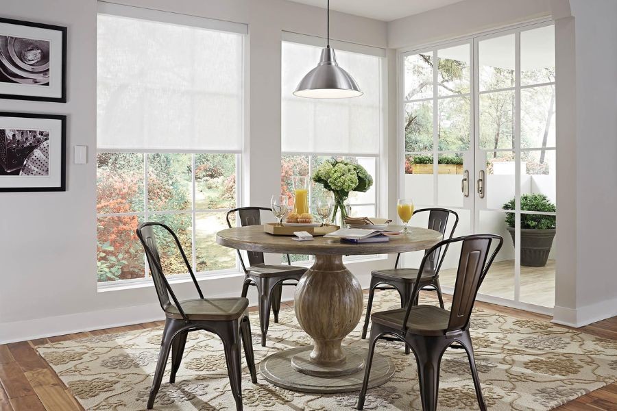 A beautiful dining room with Lutron shades on two large windows. 
